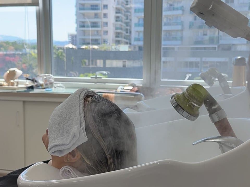 Cliente no lavatório durante a manutenção do mega hair — Magnífica, Barra da Tijuca